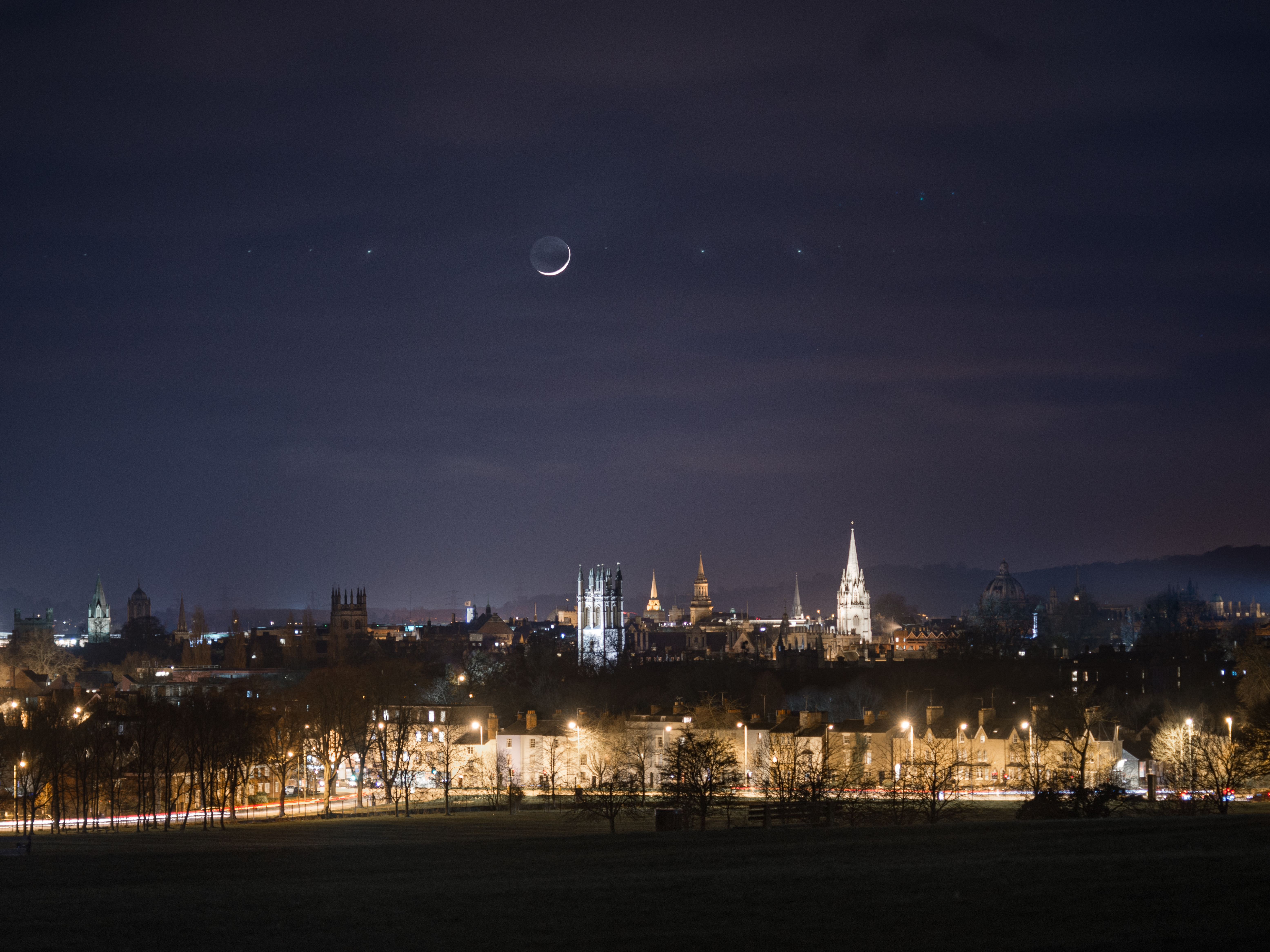 View of Oxford at night showing a new moon above the Dreaming Spires